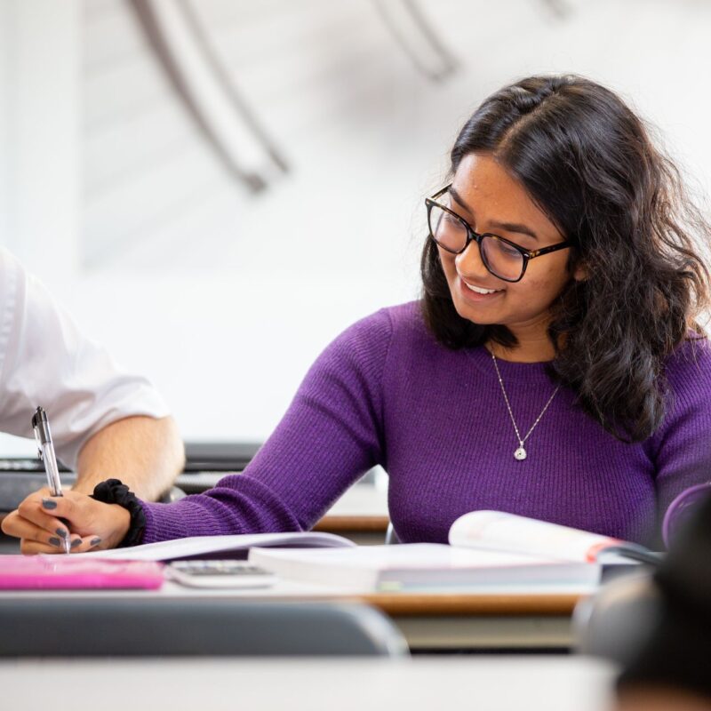 Teenage girl writing at her desk in school